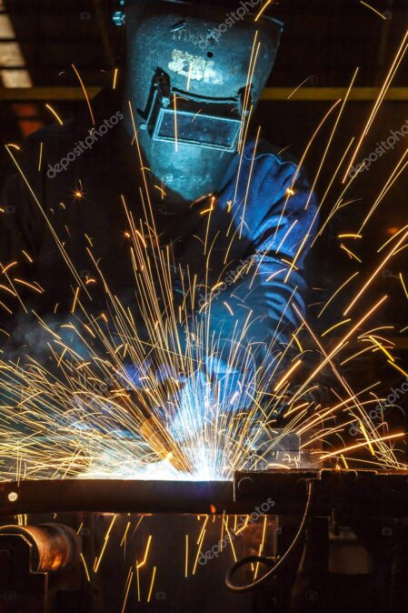 Technician welding steel frame in workshop